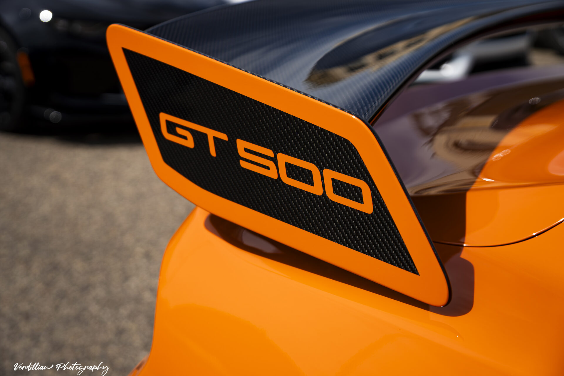 Close-up of an orange Shelby GT500's rear spoiler
