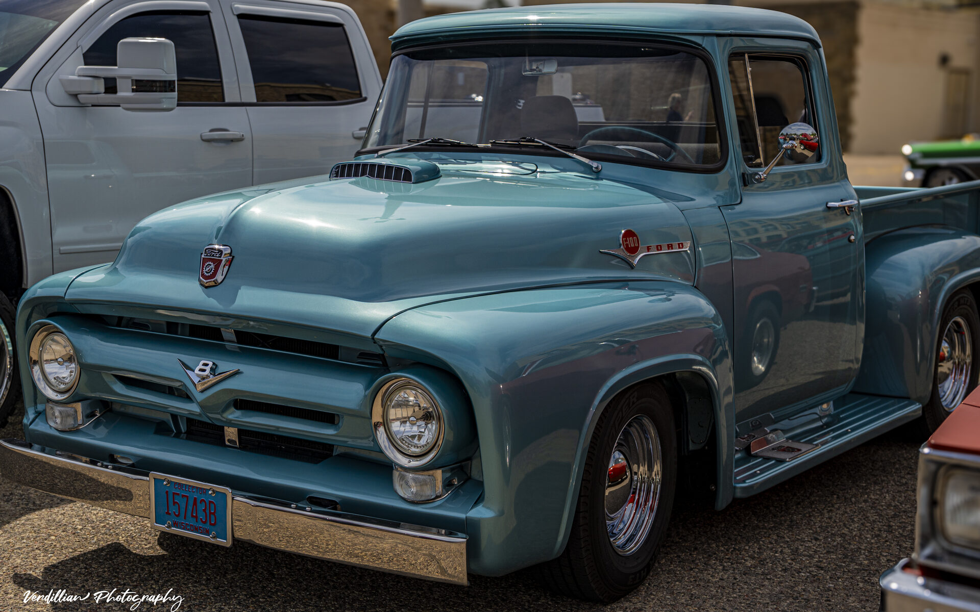 A classic light blue Ford F-100 pickup truck at a car show